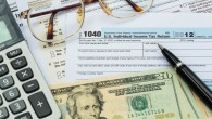 Tax form with pen, calculator, dollar banknote , and glasses tax